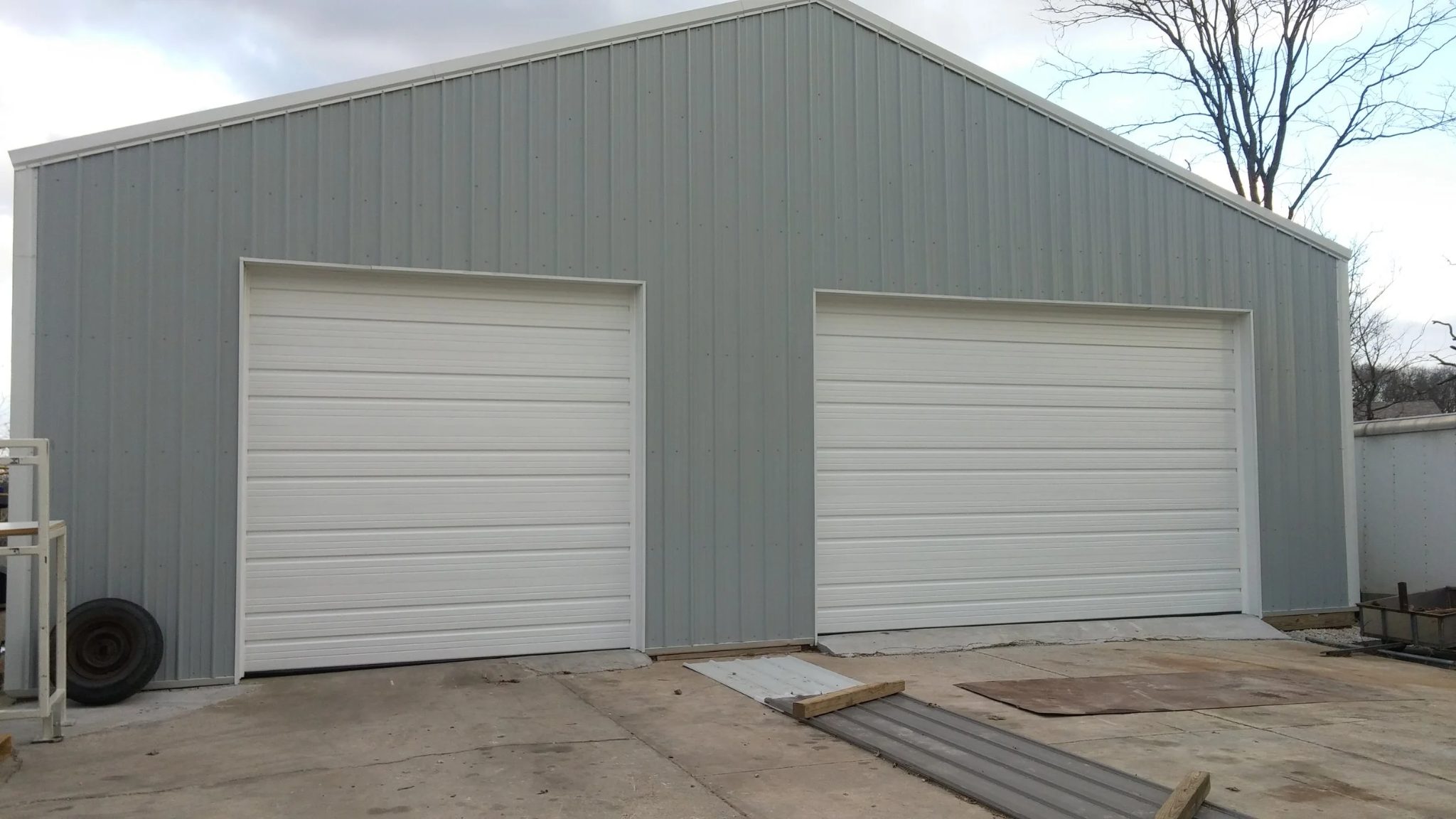 Steel commercial building with two large white sectional garage doors